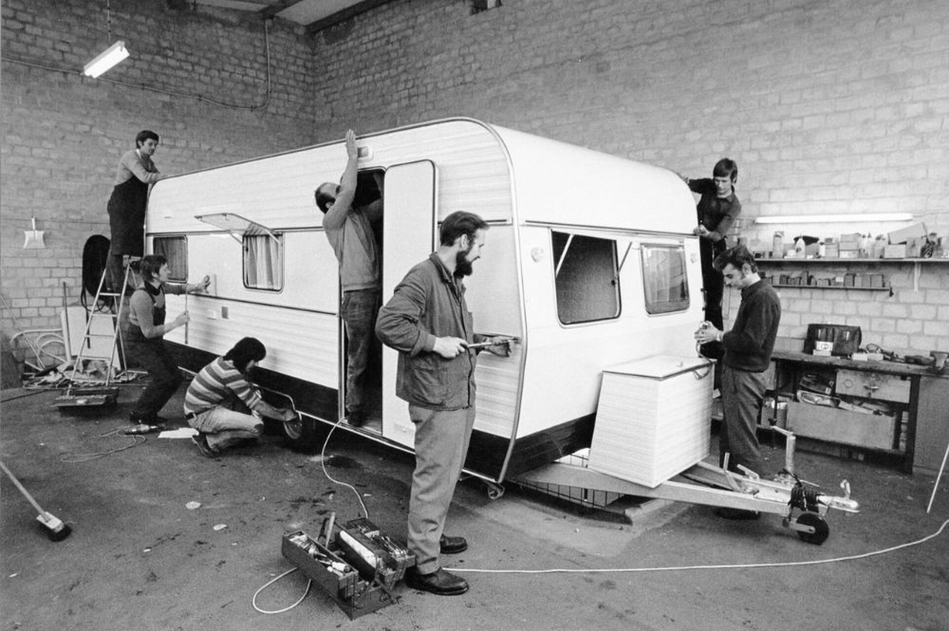 Ein Wohnwagen wird von 7 Personen gebaut in einer Halle