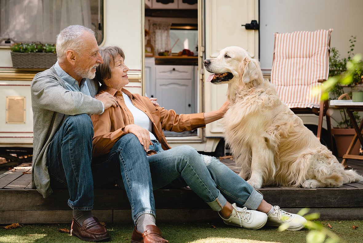 Ein altes Paar verbringt den Urlaub mit Hund und Wohnmobil auf einem hundefreundlichen Campingplatz.