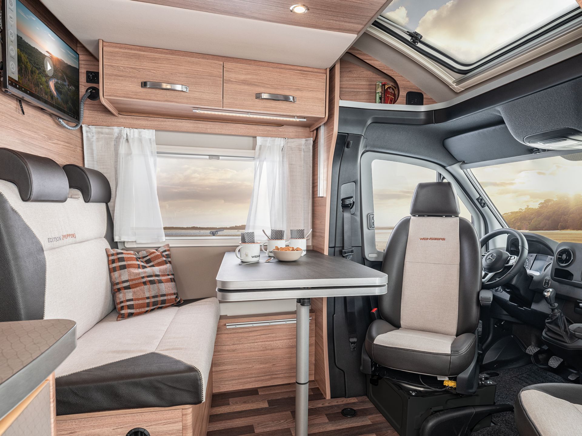 Die Sitzgruppe mit Tisch in einem Wohnmobil, die Fahrersitze sind umgedreht zum Tisch